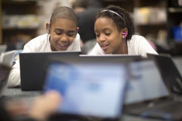 Young students helping each other learn in class