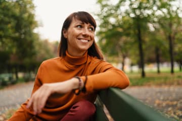 A woman on a park bench welcoming a new season