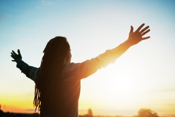  Man with arms outstretched at sunset - stock photo