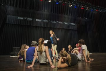 theatre student rehearsing in front of other students on stage