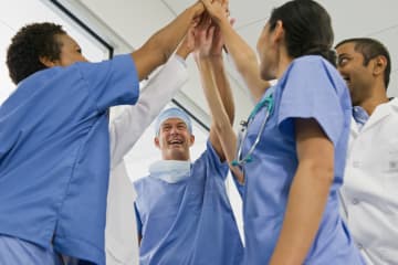 Doctors holding hands together - stock photo