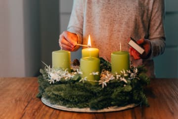 Woman lighting four seasonal candles on a table