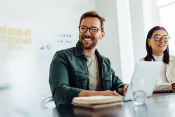 A man and woman working and smiling