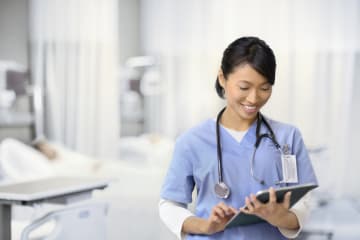 Female nurse taking notes on an electronic pad