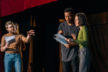  Theater director, multicultural actors and actress rehearsing on stage - stock photo