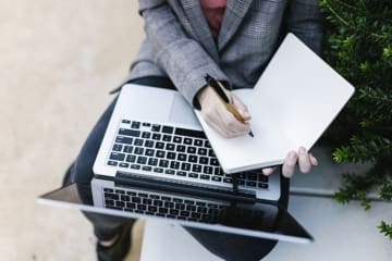 Journalist with a laptop and notepad out