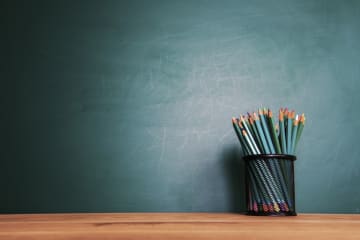 blank chalkboard and cup full of colored pencils