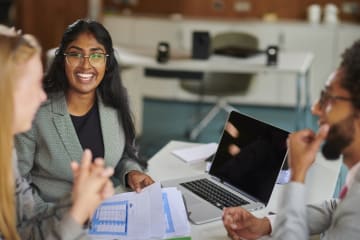 Three coworkers meeting together going over dosuments