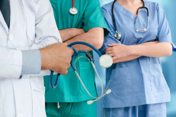 DNP vs NP students in scrubs and white coat holding stethoscope