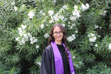 Ana Wright's graduation photo in front of flower bush