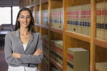 woman posing by a bookshelf