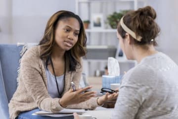 Trauma counselor is in mid-conversation with her female client