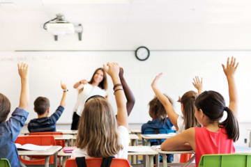 Young students raising their hands