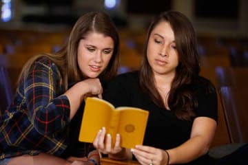 Two young women reading the Bible together