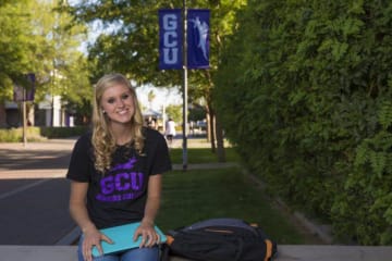 Blonde GCU Honors College student sits outside