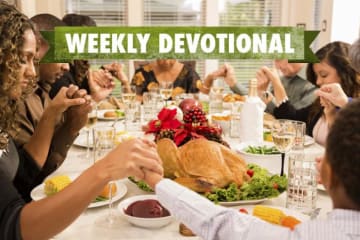 A Thanksgiving table with the Weekly Devotional banner