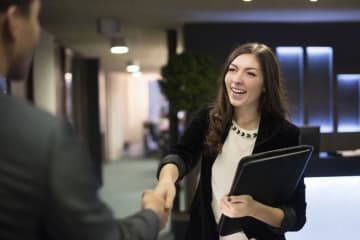 girl shaking someones hand and smiling