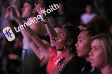 GCU students worshiping at Chapel under the Trending Faith logo