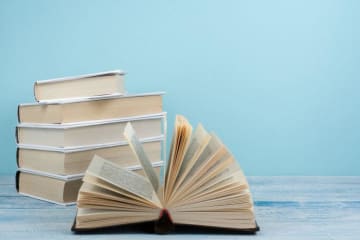 stack of books with one book open 