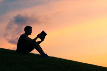 person reading at sunset