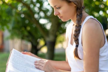 woman reading her bible outside