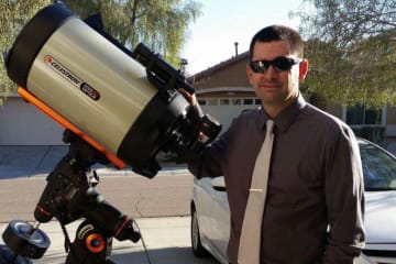 Brent Phillips at his home next to his large telescope