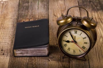 clock and bible on a table