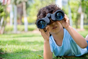 kid looking through binoculars