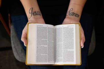 person holding open a bible