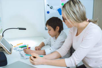 Woman teacher tutoring one student 