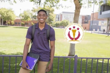 student holding notebook and wearing a backpack smiling