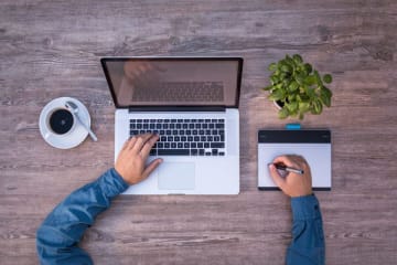 typing on computer with coffee