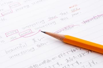 Pencil sits on top of ESL writing assignment with edits