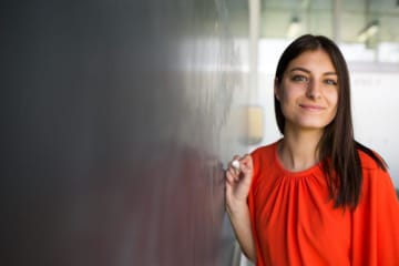 Teacher in red shirt with chalkboard