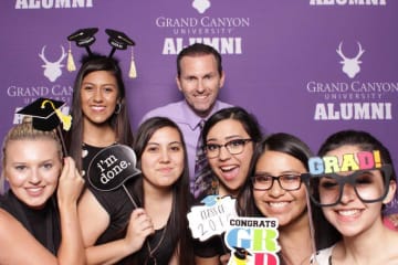 Jim Mostofo poses with recent Education graduates in GCU alumni photo booth