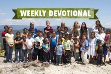 Group of global outreach volunteers standing behind students