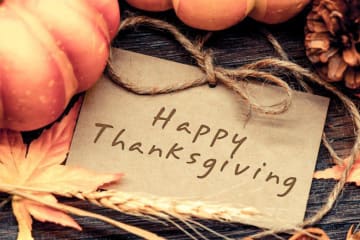 A "Happy Thanksgiving" sign with fall leaves and pumpkins