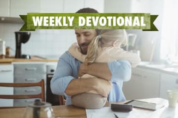 A parent hugging his child under the Weekly Devotional banner