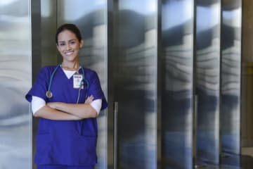 nurse leaning against wall with arms crossed