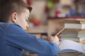 kid writing in notebook