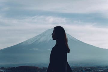 A girl looking out into the distance with a mountain behind her