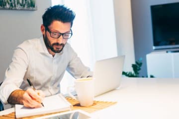 Man with glasses working on laptop