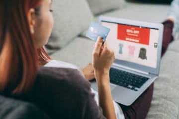 Woman shopping online with card in hand
