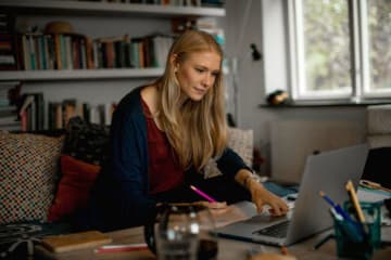 Blonde female student takes notes from online counseling class