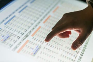 man pointing at numbers on a computer screen