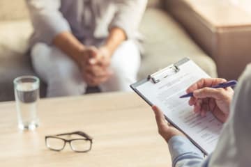 Psychologist with pen and paper in hand