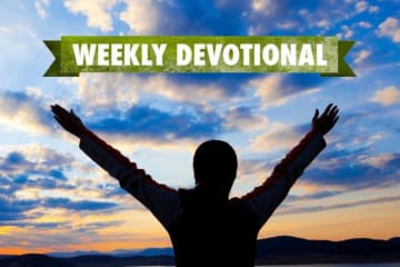 Weekly Devotional: Person with their hands up looking at the sunset