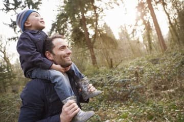 dad carrying son on his shoulders