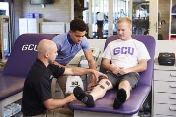 GCU student in the sports medicine room with a technician