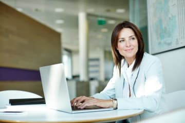 Woman looks away from her laptop screen while working